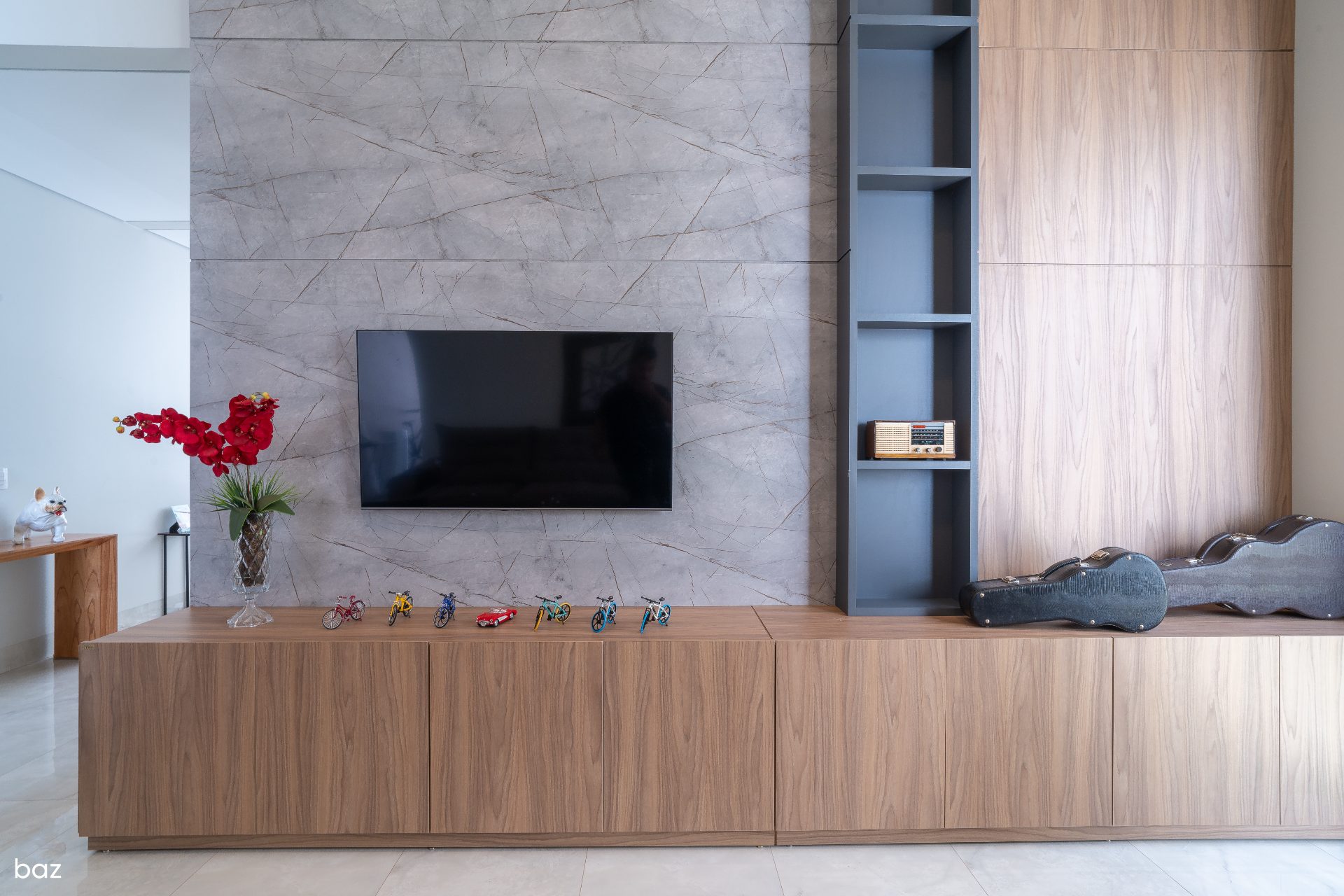Living com painel de mármore e marcenaria